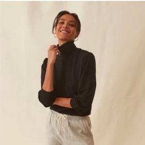 Black turtle neck with shoulder impression.